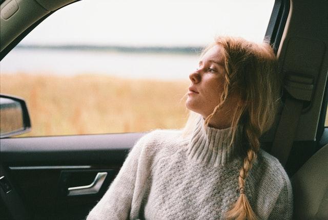 woman sitting in a car looking out the windshield